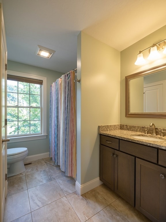 bathroom featuring tile patterned flooring, vanity, a shower with shower curtain, and toilet