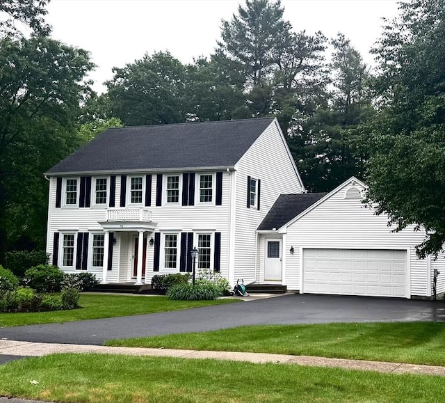 76 Wildflower Cir, Westfield, MA 01085 - colonial-style house with asphalt driveway, a garage, a front lawn, and view of scattered trees