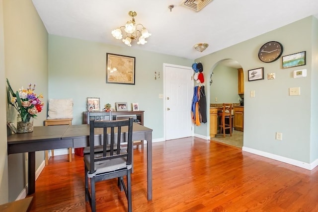 230 Willard St Unit 412, Quincy, MA 02169 - dining space featuring arched walkways, a chandelier, wood finished floors, and baseboards