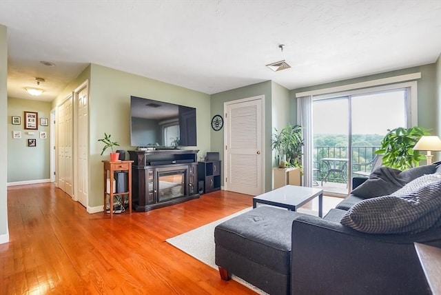 230 Willard St Unit 412, Quincy, MA 02169 - living area with wood finished floors, baseboards, and a multi sided fireplace