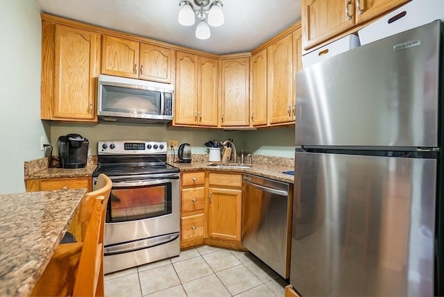 230 Willard St Unit 412, Quincy, MA 02169 - kitchen featuring stainless steel appliances, a sink, light tile patterned floors, and light stone countertops