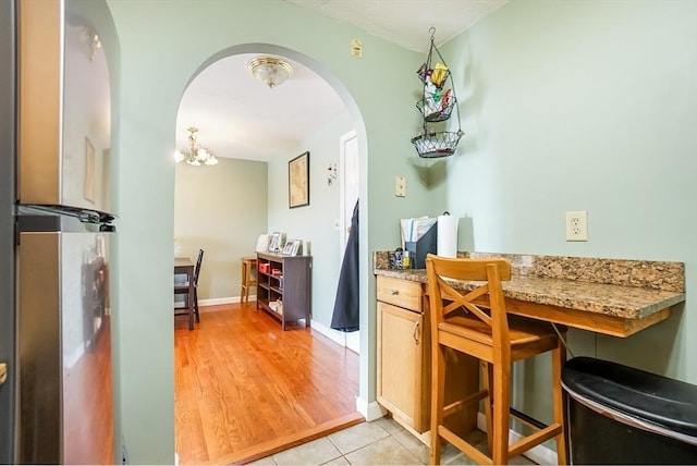 230 Willard St Unit 412, Quincy, MA 02169 - dining area with arched walkways, baseboards, light wood-style floors, and a chandelier