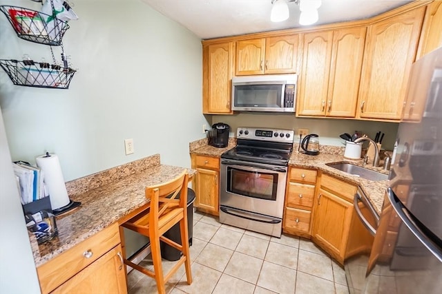 230 Willard St Unit 412, Quincy, MA 02169 - kitchen with appliances with stainless steel finishes, a sink, light stone counters, light tile patterned floors, and light brown cabinets