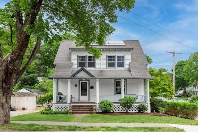 454 Webster St, Needham, MA 02494 - view of front of house featuring a porch, solar panels, a front lawn, and roof with shingles