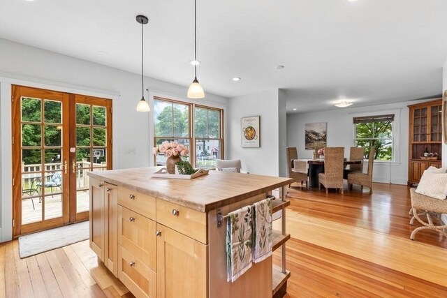 454 Webster St, Needham, MA 02494 - kitchen featuring light wood finished floors, wood counters, light brown cabinetry, french doors, and healthy amount of natural light