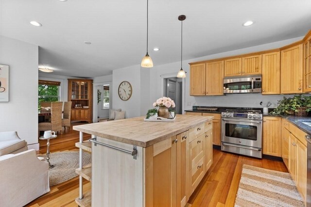 454 Webster St, Needham, MA 02494 - kitchen with appliances with stainless steel finishes, a center island, light wood-style floors, hanging light fixtures, and a kitchen breakfast bar