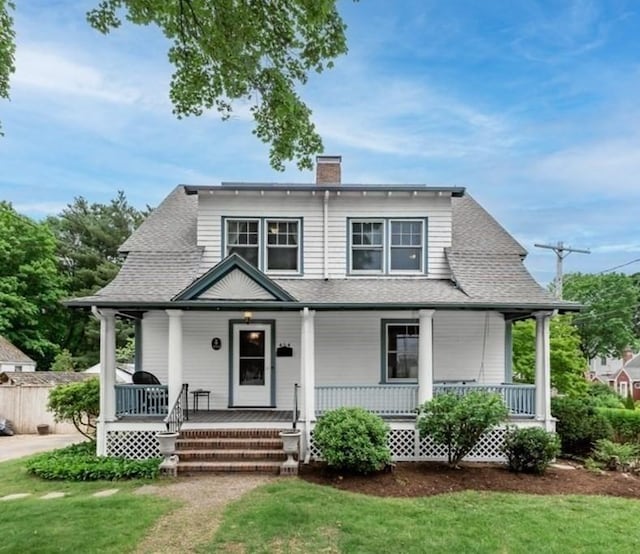454 Webster St, Needham, MA 02494 - view of front of house featuring a porch, a chimney, a front lawn, and a shingled roof