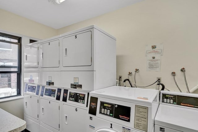 laundry room with stacked washer and dryer, a healthy amount of sunlight, and washer and clothes dryer