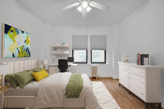 bedroom with radiator heating unit, ceiling fan, and light hardwood / wood-style floors