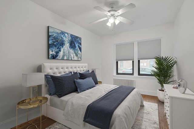 bedroom featuring radiator, hardwood / wood-style floors, and ceiling fan