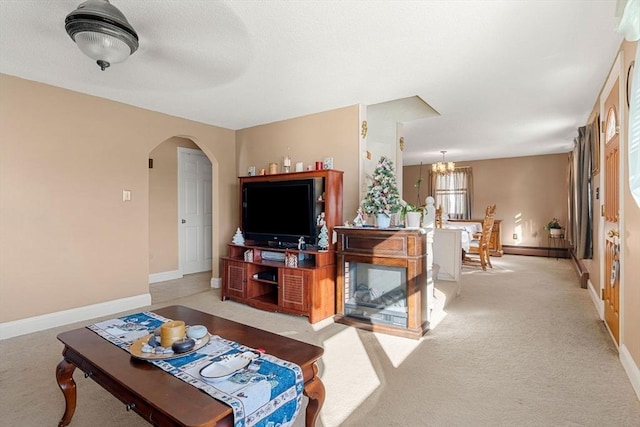 carpeted living room featuring a notable chandelier and a baseboard radiator