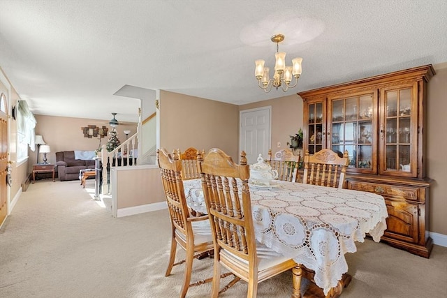 carpeted dining space featuring a textured ceiling and an inviting chandelier