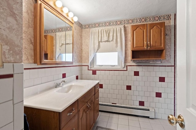 bathroom with tile patterned floors, vanity, tile walls, and a baseboard heating unit