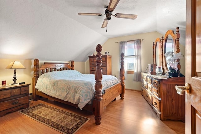 bedroom with ceiling fan, light hardwood / wood-style floors, lofted ceiling, and a baseboard radiator