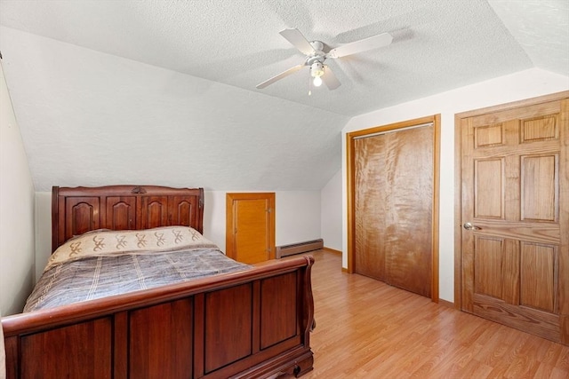 bedroom featuring vaulted ceiling, baseboard heating, light hardwood / wood-style flooring, and ceiling fan