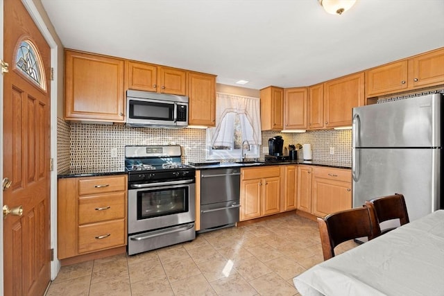 kitchen featuring backsplash, dark stone countertops, sink, and stainless steel appliances