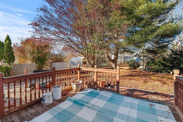 view of patio featuring a wooden deck and a shed