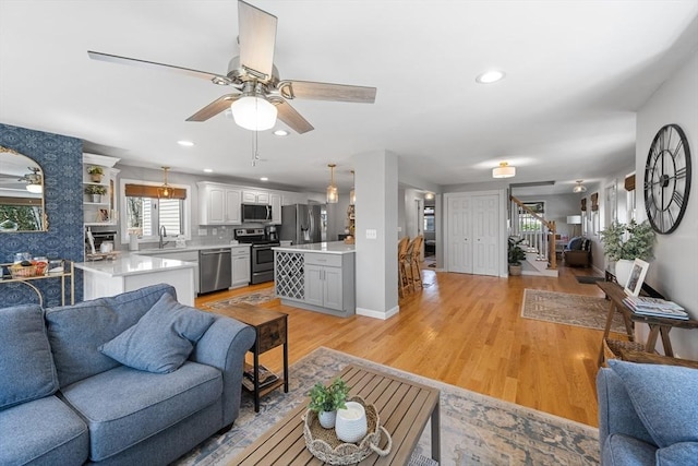 living area with recessed lighting, light wood-style floors, ceiling fan, and a healthy amount of sunlight