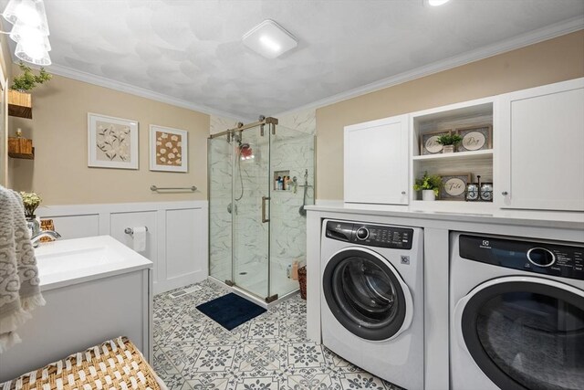 laundry area featuring a sink, washer and clothes dryer, laundry area, and crown molding