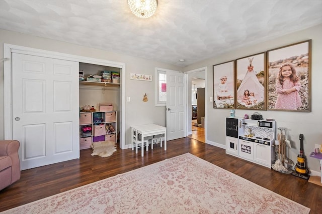 recreation room featuring wood finished floors and baseboards