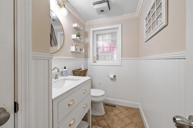 bathroom featuring tile patterned floors, a wainscoted wall, toilet, visible vents, and vanity