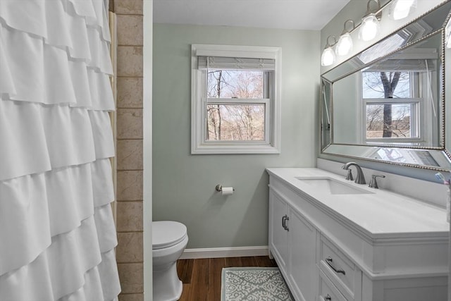 full bathroom featuring toilet, wood finished floors, vanity, baseboards, and a shower with shower curtain