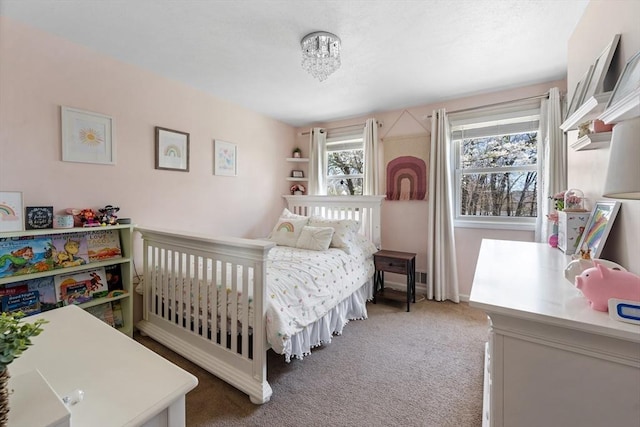 carpeted bedroom with an inviting chandelier