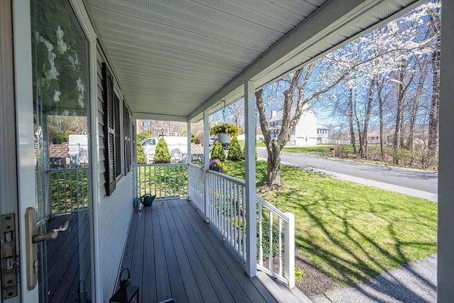 wooden deck with a porch and a lawn