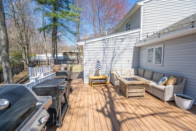 wooden terrace featuring an outdoor living space with a fire pit, a grill, and fence