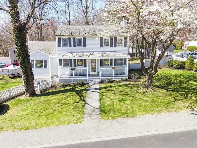 view of front facade featuring fence, a front lawn, and covered porch