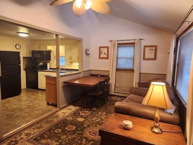 kitchen featuring vaulted ceiling, baseboard heating, kitchen peninsula, ceiling fan, and black appliances