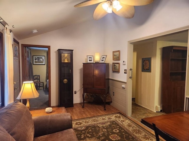 living room featuring ceiling fan, lofted ceiling, and light hardwood / wood-style flooring