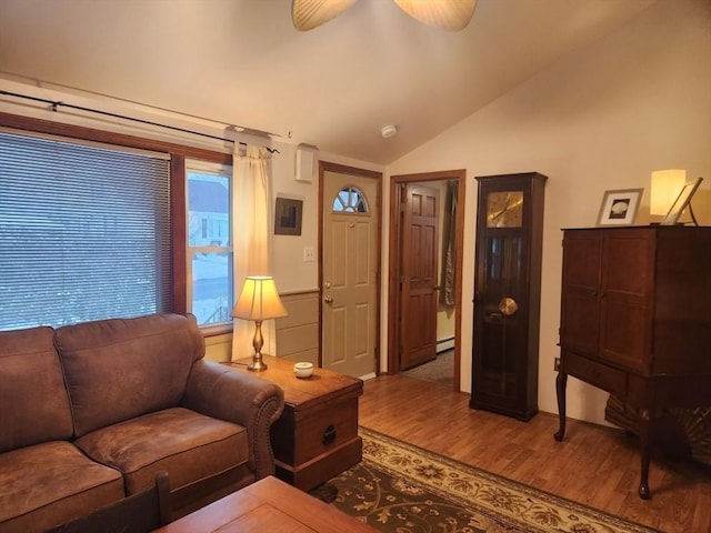 living room featuring lofted ceiling, hardwood / wood-style floors, ceiling fan, and a baseboard heating unit