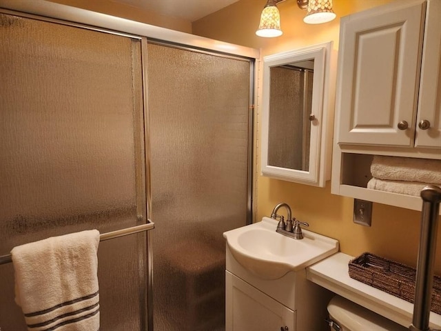 bathroom featuring vanity, an enclosed shower, and toilet