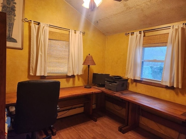 office space featuring lofted ceiling, hardwood / wood-style flooring, and ceiling fan