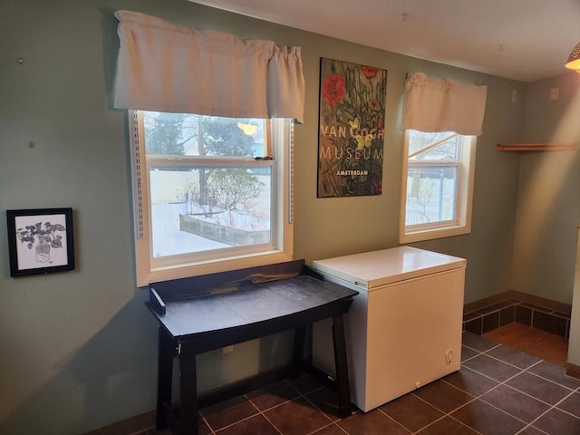 laundry area with dark tile patterned floors