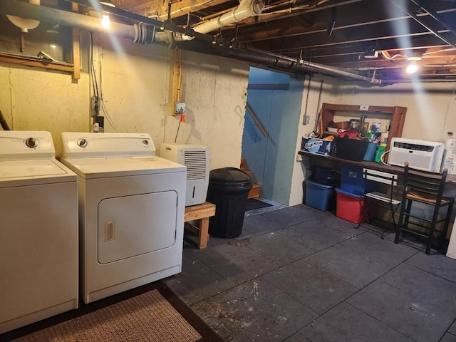 laundry area with a wall mounted AC and washing machine and clothes dryer