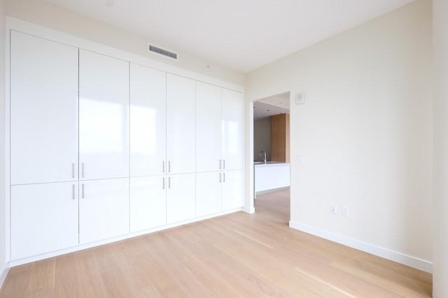 unfurnished bedroom featuring a closet and light hardwood / wood-style flooring