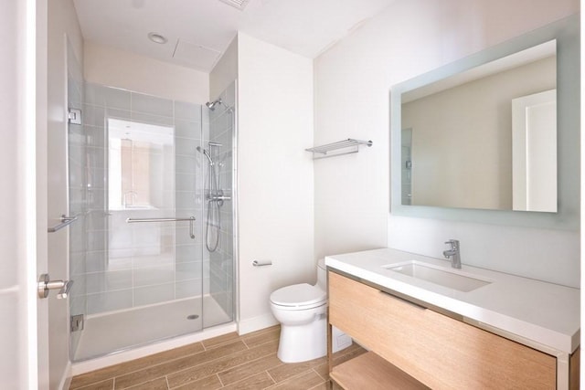 bathroom featuring vanity, an enclosed shower, and toilet