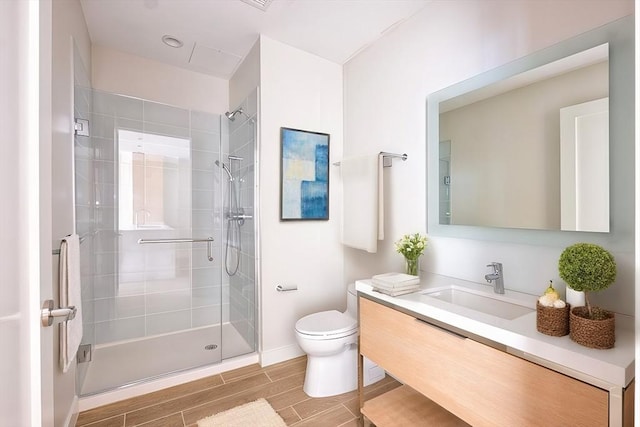 bathroom featuring vanity, an enclosed shower, and toilet