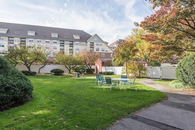 surrounding community featuring fence, a lawn, and a gate