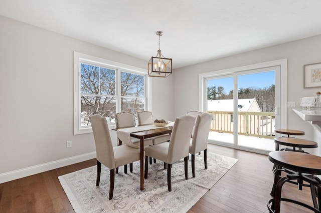 dining room with hardwood / wood-style floors and an inviting chandelier