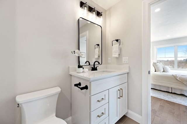 bathroom featuring vanity, hardwood / wood-style floors, and toilet