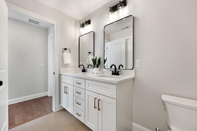 bathroom with vanity, toilet, and tile patterned flooring