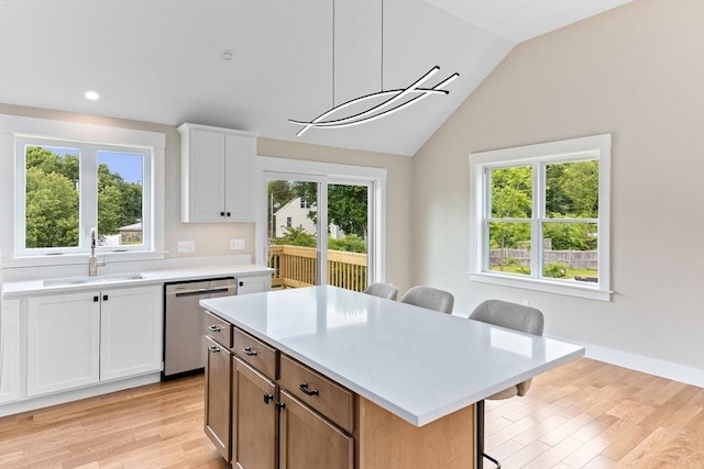 41 Kent St, Brockton, MA 02302 - kitchen featuring dishwasher, a breakfast bar, light countertops, light wood-style floors, and white cabinets