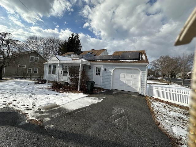 view of front of property featuring a garage and solar panels