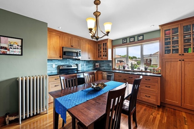 11 Raymond Rd Unit 2, Salem, MA 01970 - kitchen with stainless steel appliances, radiator heating unit, dark countertops, brown cabinets, and recessed lighting