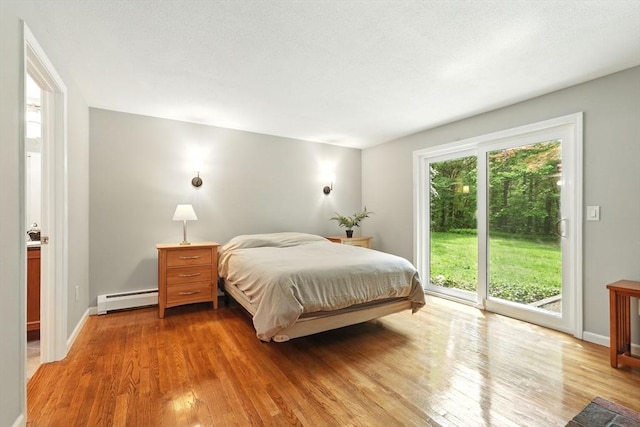 237 Shutesbury Rd, Amherst, MA 01002 - bedroom featuring a baseboard radiator, access to exterior, wood finished floors, and baseboards