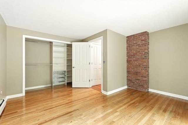 237 Shutesbury Rd, Amherst, MA 01002 - unfurnished bedroom with light wood-type flooring, a closet, baseboards, and a baseboard heating unit