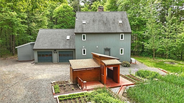 237 Shutesbury Rd, Amherst, MA 01002 - back of property with a shingled roof, a garage, a chimney, driveway, and an outdoor fire pit